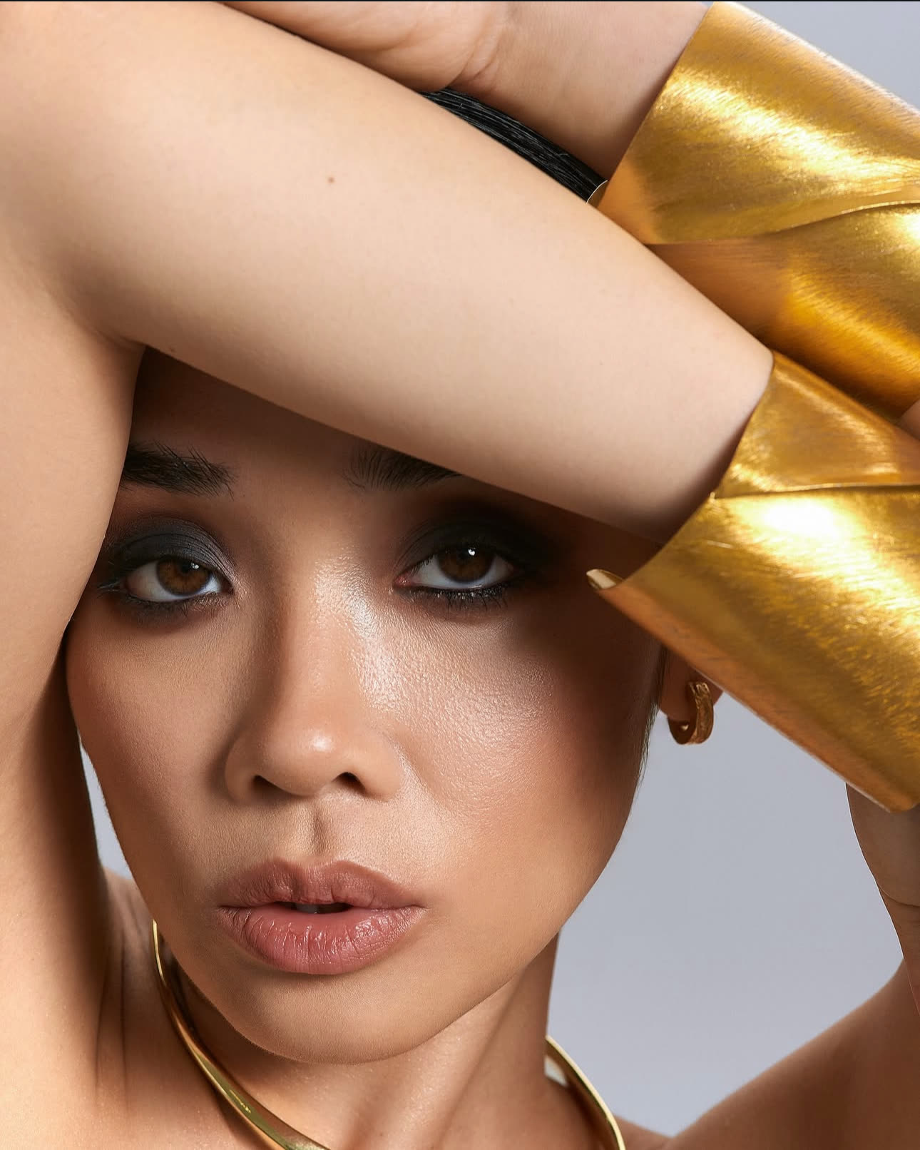 Close-up portrait with gold cuffs
