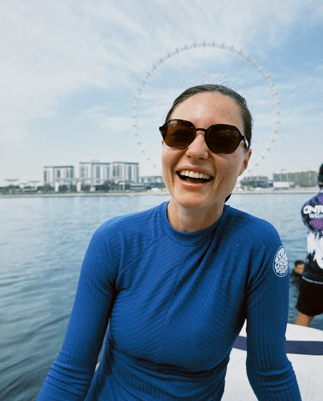 Guest laughing on the boat in a blue wetsuit