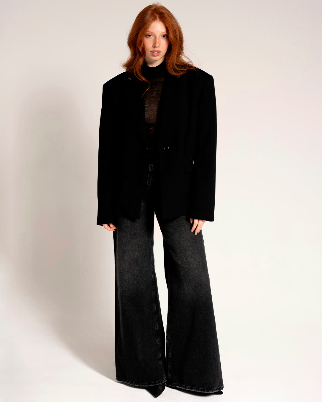 Model in a black suit on a white studio background
