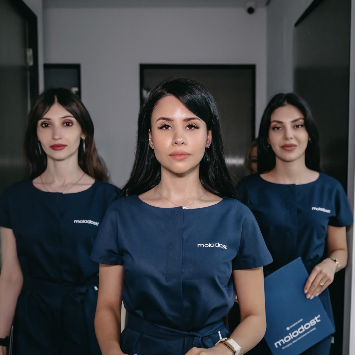 Three Molodost clinic specialists in navy uniforms